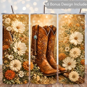 Puede incluir: Un vaso cilíndrico con pajita que presenta un diseño de botas vaqueras de cuero marrón con patrones florales, rodeado de margaritas blancas y naranjas y vegetación sobre un fondo cálido y dorado con efecto bokeh.