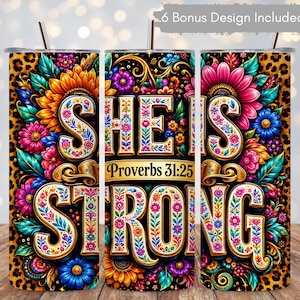May include: A cylindrical tumbler featuring a leopard print background and vibrant, multi-colored floral patterns. The text reads "SHE IS STRONG" and "Proverbs 31:25" in a decorative, ornate font. A metal straw is inserted into the top lid.