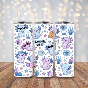 Peut inclure: Un gobelet cylindrique blanc avec une paille transparente orn&eacute; d'un motif r&eacute;p&eacute;titif d'axolotls bleu et violet clair, de bulles et de plantes aquatiques. Le texte inclut AXOLOTL VIBES, STAY COOL, JUST CHILL, SUP, WATER BUD et NO THOUGHTS JUST GILLS.
