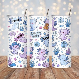 Peut inclure: Un gobelet cylindrique blanc avec une paille en m&eacute;tal orn&eacute; d'un motif r&eacute;p&eacute;titif d'axolotls bleu clair et violets, de bulles et d'algues. Le texte inclut "STAY COOL", "AXOLOTL VIBES", "SUP, WATER BUD?", "JUST CHILL" et "NO THOUGHTS JUST GILLS".