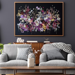 K&ouml;nnte beinhalten: Ein rechteckiges Wandbild mit einer dichten Anordnung gepresster Blumen und Bl&auml;tter in Violett-, Rosa-, Gelb- und Gr&uuml;nt&ouml;nen vor einem einfarbigen schwarzen Hintergrund, eingefasst in einen d&uuml;nnen, hellen Holzrahmen.