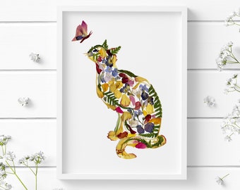 May include: A white framed print of a cat made from pressed flowers and leaves. The cat is sitting and looking to the left. A small butterfly is flying above the cat's head.
