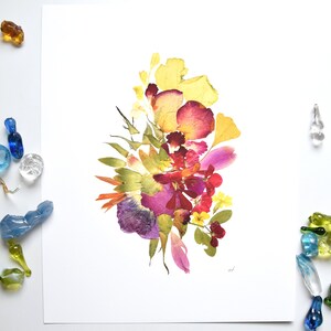 A white background with a bouquet of pressed flowers in shades of yellow, pink, red, purple, and green. The flowers are arranged in a loose, organic shape.