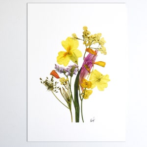 Puede incluir: Un arreglo de flores prensadas con flores amarillas, naranjas y moradas sobre un fondo blanco. Las flores est&aacute;n dispuestas en forma de ramo y est&aacute;n rodeadas de hojas verdes.