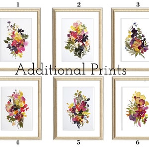 Six framed floral prints with a white background and gold frames. The prints feature pressed flowers in various shades of pink, yellow, and purple.