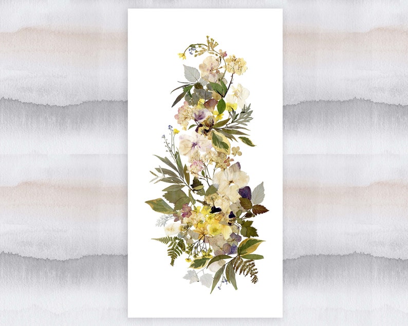 May include: A vertical arrangement of pressed flowers in shades of white, yellow, and green. The flowers are arranged in a cascading pattern, with the largest flowers at the top and the smallest flowers at the bottom.