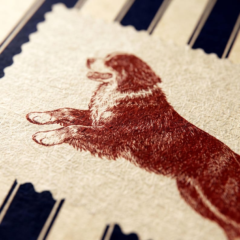 Puede incluir: Una tarjeta rectangular con borde dentado que presenta una ilustraci&oacute;n de color rojo oscuro de un perro en posici&oacute;n de salto. La tarjeta tiene una superficie texturizada de color blanco roto sobre un fondo de rayas verticales azul oscuro y crema.