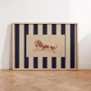 Puede incluir: Una pieza de arte mural rectangular enmarcada que presenta un rectángulo central de color tostado con bordes festoneados, con un dibujo lineal de color marrón rojizo de un Cavalier King Charles Spaniel corriendo, sobre un fondo de rayas verticales azul marino y tostado.