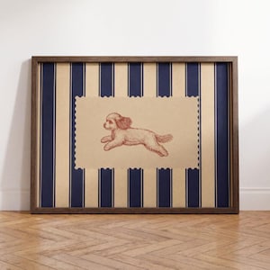 Op de afbeelding: Een ingelijst kunstwerk aan de muur met een donkerbruine houten lijst. De achtergrond bestaat uit verticale marineblauwe en beige strepen. In het midden bevindt zich een beige rechthoekig inzetstuk met geschulpte randen en een rode lijntekening van een kleine hond.
