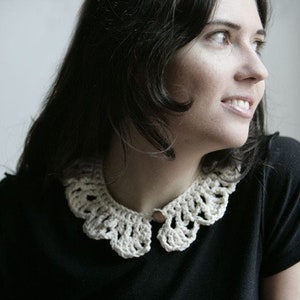 Peut inclure: Une femme aux cheveux foncés porte une chemise noire avec un col en crochet blanc.