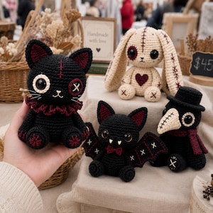 Puede incluir: Una colección de cuatro peluches de ganchillo hechos a mano que incluye un gato negro con cuello de volantes rojo, un conejo color crema con detalles cosidos, un murciélago negro con detalles rojos y un médico de la peste con sombrero.