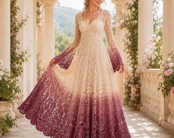 Puede incluir: Un vestido largo de ganchillo con escote corazón y mangas largas acampanadas. La prenda presenta un degradado de color, comenzando con un tono crema en el corpiño y desvaneciéndose hacia un tono burdeos intenso en el dobladillo festoneado.