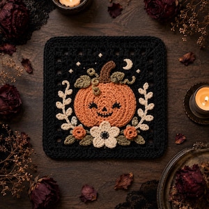 May include: A square crochet granny square featuring a central orange pumpkin with a smiling face, surrounded by cream-colored flowers, green leaves, and small white stars and a crescent moon, all set against a solid black yarn background.