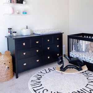 Black nursery dresser with natural wood animal-shaped knobs