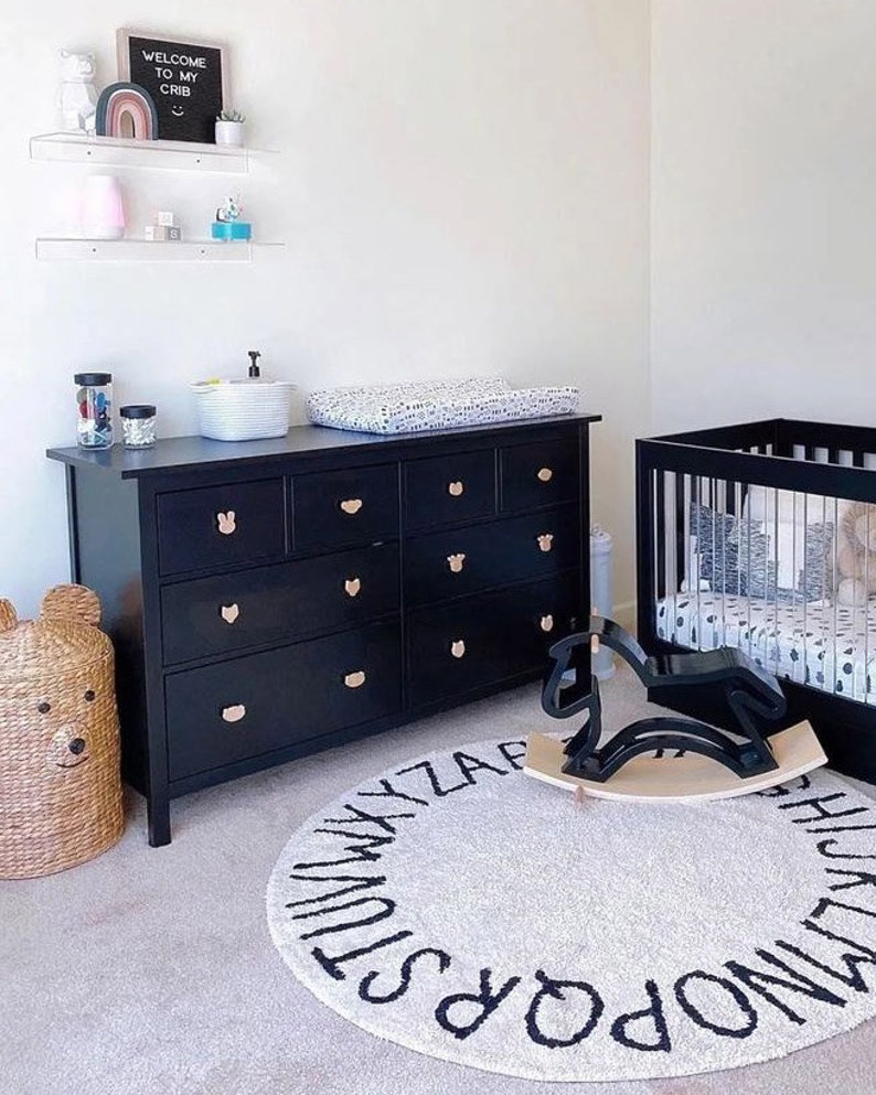 Black nursery dresser with natural wood animal-shaped knobs