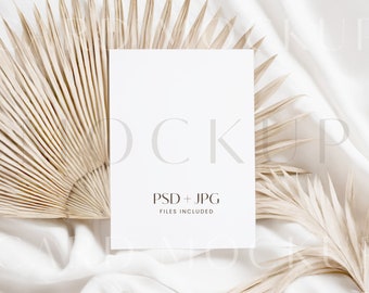 Può includere: Un mockup di una carta bianca con il testo "PSD + JPG FILES INCLUDED" su uno sfondo bianco con foglie di palma secche.