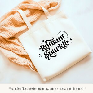 May include: White canvas tote bag with black text that reads "Radiant Sparkle" and "Your Tagline".