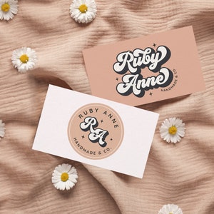 May include: Two business cards with a pink and white background. The first card features the text "Ruby Anne Handmade & Co." in a retro font. The second card features a circle with the text "Ruby Anne Handmade & Co." and the initials "RA" in a retro font.