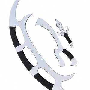 May include: A set of three silver-colored metal blades with curved, pointed designs and black cord-wrapped handles. The largest blade is crescent-shaped with multiple cutouts, while the two smaller pieces feature distinct, sharp, angular points.