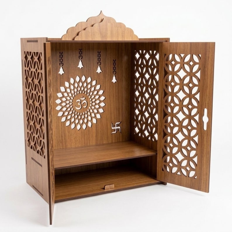 May include: A brown wooden home temple featuring an open front with two side doors. The back panel displays a laser-cut Om symbol surrounded by a circular floral pattern, four hanging bell cutouts, and a small swastika symbol on the right side.