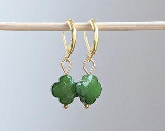 Peut inclure: Une paire de boucles d'oreilles créoles dorées avec des breloques en forme de trèfle vert.