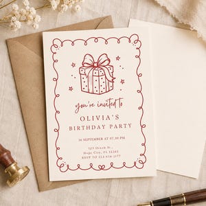 May include: A cream-coloured birthday party invitation card with a red line-art illustration of a gift box and a decorative curly border. The text reads: you're invited to OLIVIA'S BIRTHDAY PARTY, 16 SEPTEMBER AT 07.30 PM, 123 Ocean St., Hope City, FL 12345, RSVP TO 123-456-1177.