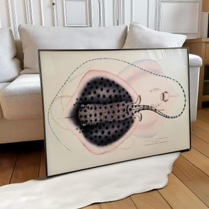 May include: Framed art print featuring a detailed illustration of a stingray. The artwork showcases a black and gray spotted body with pink and white accents. The print is set in a black frame, adding a touch of elegance to the marine-themed artwork.