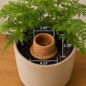 May include: A small, round, terracotta-colored plant pot insert with a textured, ridged exterior surface. The insert features a central opening and is marked with dimensions of 2.83 inches in diameter, 4.13 inches at the base, and 2.28 inches in height.
