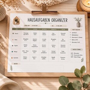 May include: A wooden clipboard with a printed "HAUSAUFGABEN ORGANIZER" weekly planner. The planner includes sections for each day of the week, with subjects like Math, English, and Biology. A pen, candle, and decorative items surround the clipboard.