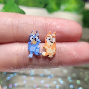 Pendientes de botón con forma de hermana perrita en tonos azules y naranjas