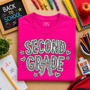 Può includere: Una t-shirt a maniche corte rosa acceso con la scritta SECOND GRADE in un motivo maculato bianco e nero. Il design include un fiocco centrale, piccole stelle e cuori. La maglietta ha un girocollo e un'etichetta di taglia large.