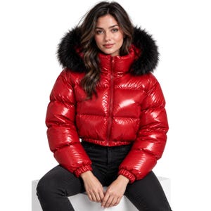 Pode incluir: Um casaco acolchoado vermelho brilhante com gola alta, fecho de correr frontal e capuz com acabamento em pelo sintético preto espesso. O casaco apresenta um corte curto com mangas compridas e punhos elásticos de acabamento lustroso.
