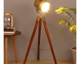 Lámpara de pie de metal y latón con trípode de madera y altura ajustable.