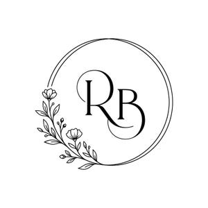 May include: A black and white graphic logo featuring the letters RB in a stylised serif font, enclosed within a thin circular frame. A delicate floral branch with leaves and small blossoms extends along the lower left side of the circle.