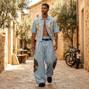 Peut inclure: Ensemble deux pièces bleu clair composé d'une chemise à manches courtes avec des motifs floraux et d'un pantalon large. La chemise a un col mandarin et le pantalon des motifs floraux. Une ceinture et des chaussures noires complètent l'ensemble.