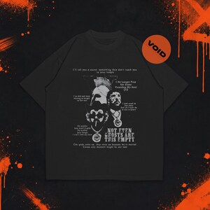 May include: A black short-sleeve t-shirt featuring a white graphic print with portraits of two individuals, one wearing a cowboy hat and sunglasses. The design includes text such as "NOT EVEN GHOSTS ARE THIS EMPTY" and "I No Longer Fear the Razor."