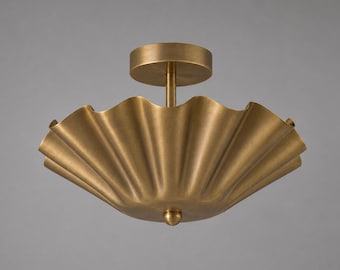 May include: A flush mount ceiling light fixture with a wide, scalloped, bowl-shaped shade in a brushed brass finish. The fixture features a central stem connecting the shade to a circular canopy and a small, rounded finial at the bottom center.