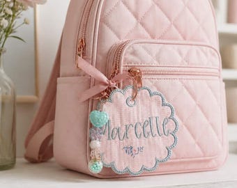 Etiqueta personalizada bordada: Etiqueta personalizada para mochila con cierre y colgantes.