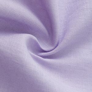 May include: A close-up view of light purple fabric with a visible woven texture. The material is gathered in the center, creating soft folds and shadows that highlight the consistent lavender hue and the natural weave of the textile fibers.