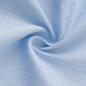 May include: A light blue fabric with a visible woven texture and a soft, matte finish. The material is gathered in the center, creating natural folds and shadows that highlight the consistent weave pattern and the solid, pale blue color throughout.