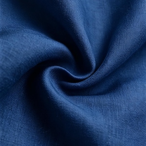 May include: A deep blue fabric with a visible woven texture and a natural fiber appearance. The material is gathered into soft, flowing folds that create subtle shadows and highlights across the surface, emphasizing the rich, solid color.