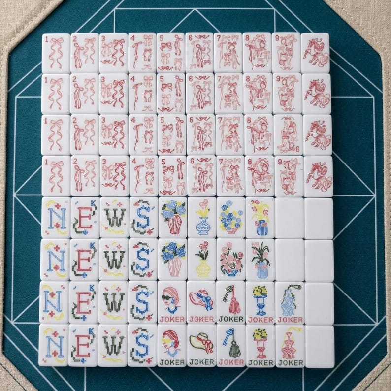 Op de afbeelding: Een set witte mahjongtegels gerangschikt in een raster. De bovenste rijen bevatten rode lijntekeningen van linten en paarden, genummerd van &eacute;&eacute;n tot negen. De onderste rijen tonen het woord NEWS in blauw en zwart, bloemenvazen en JOKER-tegels.