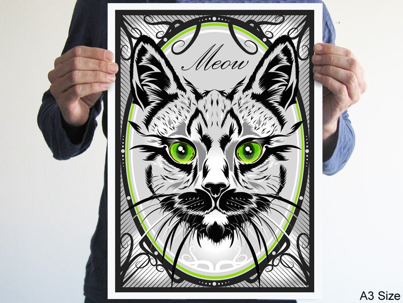 Puede incluir: Ilustraci&oacute;n en blanco y negro de la cara de un gato con ojos verdes, enmarcada en un marco decorativo con la palabra "Meow" en una fuente estilizada.