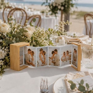 May include: A light-coloured wooden accordion-style photo frame holding a series of five vertical photographs featuring a couple in wedding attire. The frame is constructed with two rectangular wooden end pieces connected by a folding paper strip.