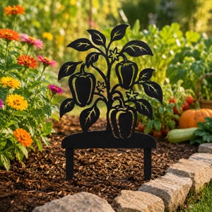 May include: A black metal garden stake featuring a silhouette design of a pepper plant with three bell peppers, several leaves, and small flowers. The flat, decorative piece has two prongs at the base for insertion into the soil.