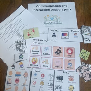 May include: A set of communication and interaction support resources. The pack includes cards with phrases such as "My turn," "I want," and "Please." Visual aids with icons and text are designed to assist communication. The colour scheme includes pink, blue, and white.