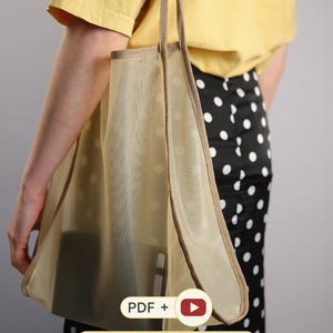 May include: A sheer beige tote bag with a white polka dot pattern and tan fabric trim. The bag features long shoulder straps and contains a dark rectangular object. Text on the image reads: PDF + [play icon] +BONUS DRAWSTRING POUCH.
