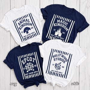 Pu&ograve; includere: Quattro magliette a maniche corte con girocollo in blu navy e bianco. Ogni maglietta presenta una grafica a righe verticali con i nomi dei parchi Walt Disney World: Animal Kingdom, Magic Kingdom, Epcot e Hollywood Studios.