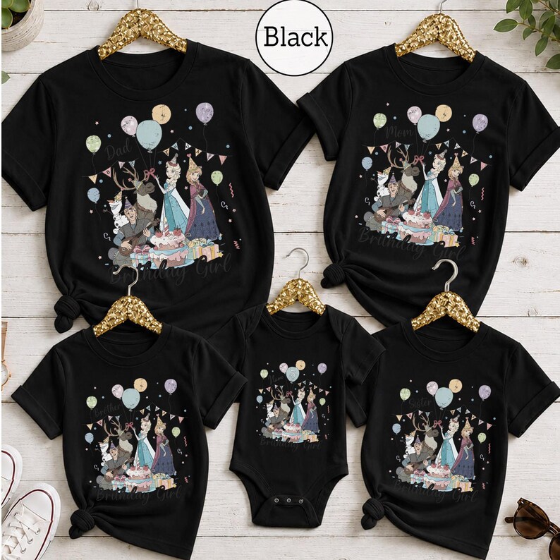 Op de afbeelding: Een set van vijf zwarte t-shirts en &eacute;&eacute;n zwarte romper met een grafische print van personages uit Frozen, waaronder Elsa, Anna, Olaf en Sven. Het ontwerp bevat ballonnen, een verjaardagstaart, cadeautjes en de tekst Birthday Girl.