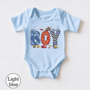 May include: A light blue short-sleeve bodysuit featuring the word BOY in large letters. The B is blue with lightning bolts, the O is red with lightning bolts, and the Y is black and white checkered. Characters from the movie Cars are included.